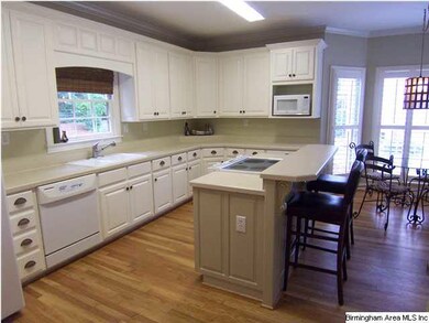Island has smooth top stove and bar. Microwave and