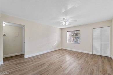 Unfurnished bedroom with light wood-style flooring, a closet, and a ceiling fan