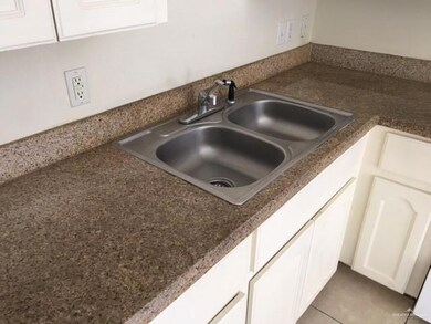 Kitchen view of dark countertops and white cabinetry