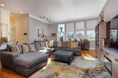 Living room featuring ornamental molding, light wo