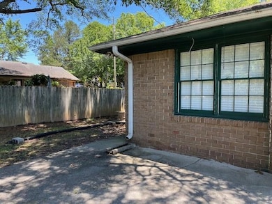View of property exterior with brick siding and a patio area