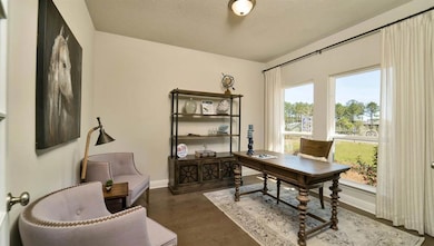 Home office featuring a textured ceiling and wood finished floors