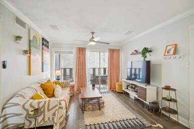 Living room featuring wood finished floors, crown