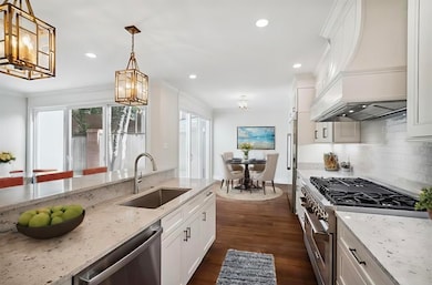 Kitchen with white cabinets, dark wood-type floori