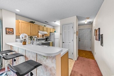 Kitchen with a breakfast bar, white appliances, an