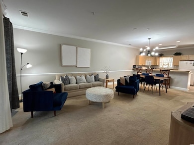 Carpeted living room featuring crown molding and a