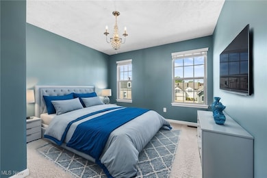  *Virtually Staged Bedroom with a textured ceiling, a notable chandelier, and carpet