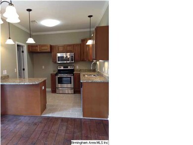 Kitchen has granite counters and ceramic floors.