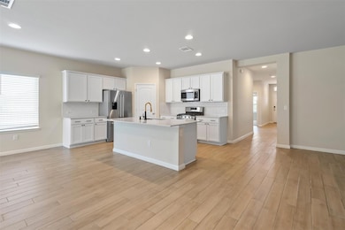 Kitchen with light countertops, light wood finish