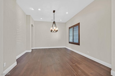 Unfurnished room with arched walkways, a chandelie