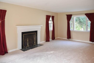 The living room offers a picture window and a fire