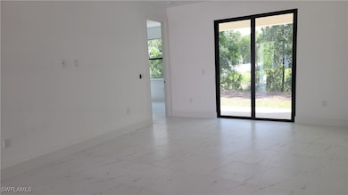 Spare room featuring baseboards and light marble f