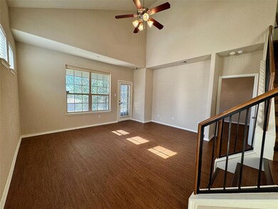 Unfurnished room featuring high vaulted ceiling, stairs, wood finished floors, and ceiling fan