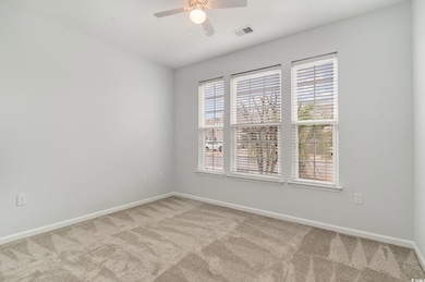 Carpeted empty room featuring ceiling fan