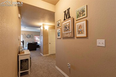 Hallway featuring a textured ceiling and carpet fl