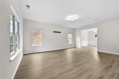 Spare room with plenty of natural light, wood finished floors, and baseboards