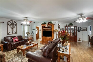 Living room with a ceiling fan and light wood-style flooring