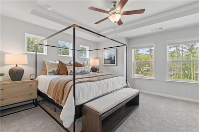 Bedroom with light colored carpet and a ceiling fan