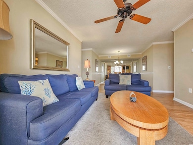 Living area with a ceiling fan, a chandelier, wood finished floors, a textured ceiling, and baseboards