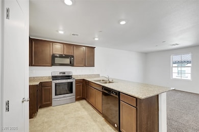 Kitchen featuring visible vents, a peninsula, a si