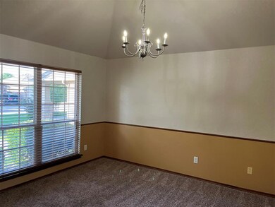 Carpeted spare room featuring a notable chandelier