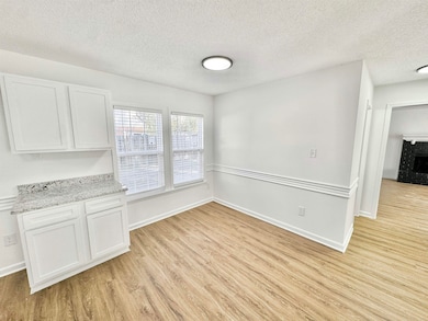 Unfurnished dining area with a textured ceiling and light wood-style floors