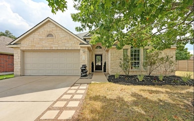 View of front of home featuring stone siding, concrete driveway, and a garage