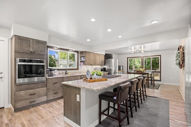 Kitchen featuring appliances with stainless steel finishes, a breakfast bar, a kitchen island, healthy amount of natural light, and recessed lighting