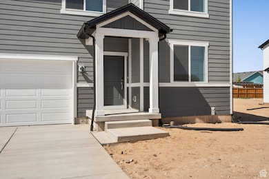 Doorway to property with a garage and concrete driveway