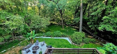Beyond the deck is a fire pit and lush garden.