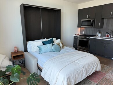 Bedroom featuring a sink and wood finished floors