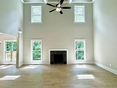 Unfurnished living room featuring ceiling fan, bea