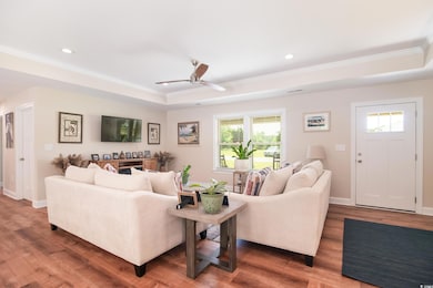 Living area with crown molding, a tray ceiling, he