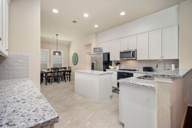 Recently updated kitchen includes granite counters, tile backsplash, SS appliances, and high-end tile flooring.