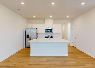 Kitchen featuring sink, white cabinetry, stainless