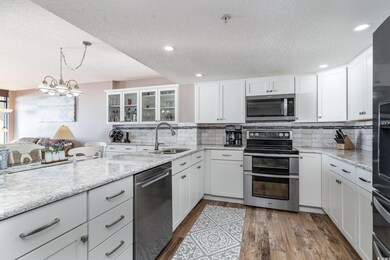 Kitchen featuring white cabinetry, appliances with