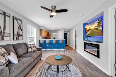 Living room with a ceiling fan, a glass covered fi