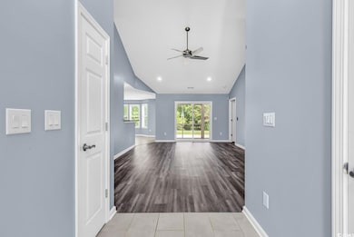 Hall with baseboards, recessed lighting, wood fini