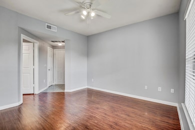 Spare room featuring a ceiling fan and dark wood 