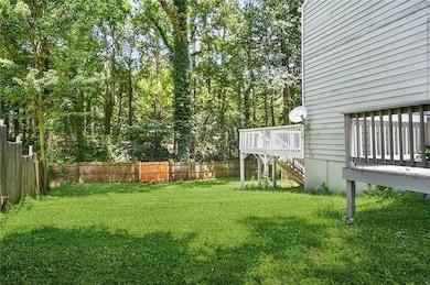 Fenced backyard featuring a wooden deck and stairs