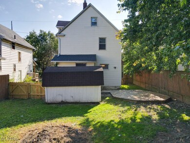 Back of property featuring a storage unit, a fenced backyard and a deck