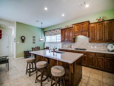 ....where you can entertain guests at breakfast bar/island while preparing a meal on your gas range.  Notice the beautiful wood grain on the cabinets.