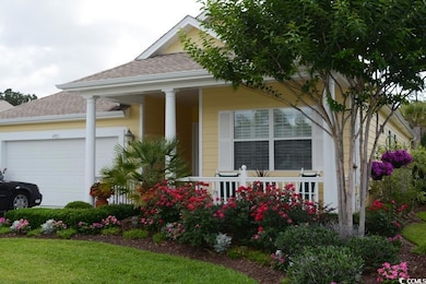 View of front of property featuring an attached garage, a shingled roof, and covered porch