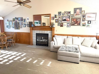 Living room, vaulted ceiling, fireplace, wainscotting, and shutters!