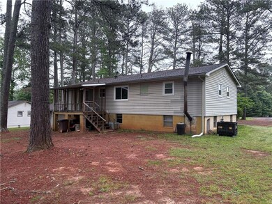 Rear view of property featuring stairway, cooling 