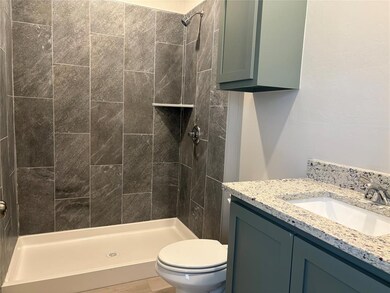 Full bath with toilet, a stall shower, and vanity