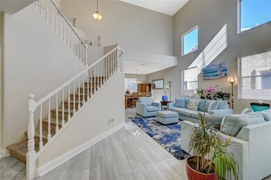Living area with stairway, baseboards, a high ceil