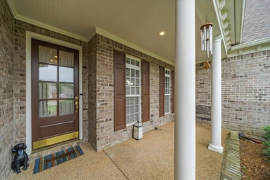 Doorway to property with brick siding and a porch
