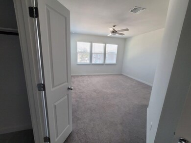 Empty room featuring a ceiling fan, carpet, and b