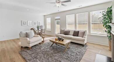 Living room featuring baseboards, ceiling fan, and light wood-style floors